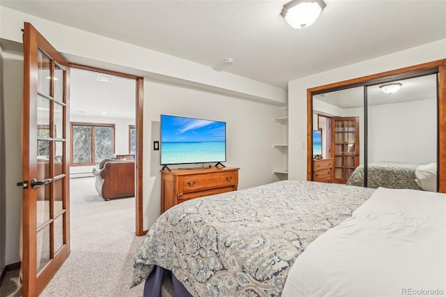 bedroom with carpet floors, french doors, a closet, and baseboard heating