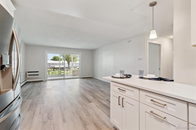 kitchen with hanging light fixtures, white cabinetry, baseboard heating, and stainless steel fridge with ice dispenser