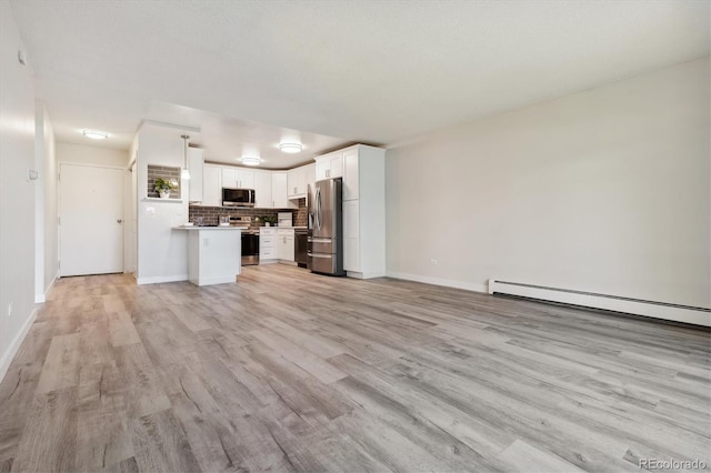 unfurnished living room featuring baseboard heating, white cabinetry, pendant lighting, and light hardwood / wood-style flooring