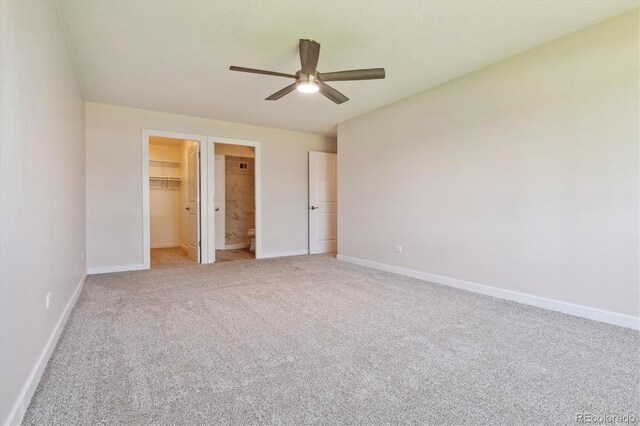 unfurnished bedroom featuring ceiling fan, carpet, a closet, and a spacious closet