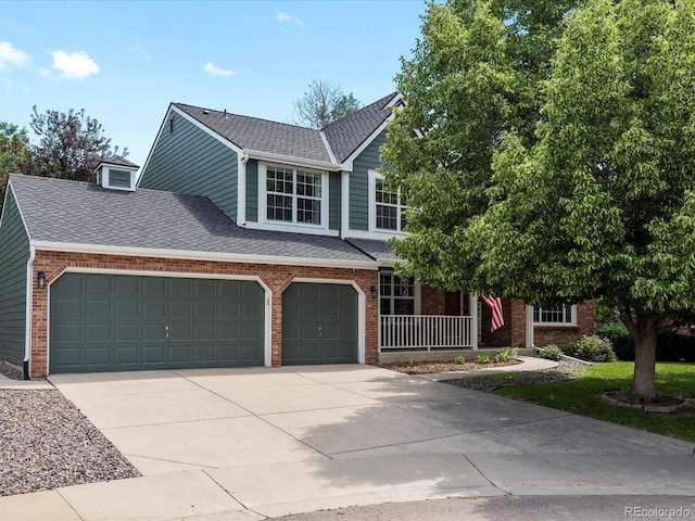 8953 W Brandt Pl, Littleton, CO 80123 - view of front of house featuring brick siding, driveway, covered porch, and a shingled roof