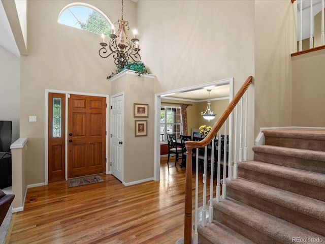 8953 W Brandt Pl, Littleton, CO 80123 - entryway featuring a towering ceiling, light wood finished floors, stairway, and a chandelier