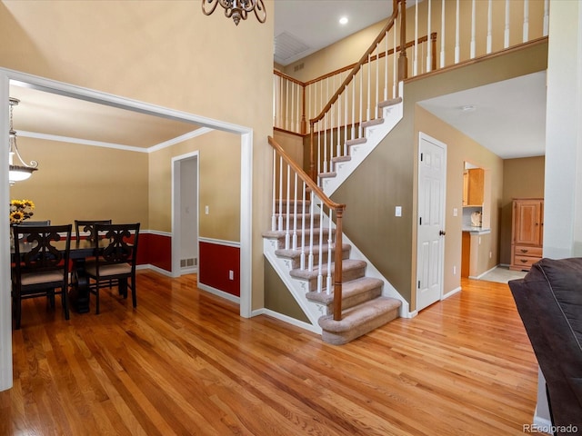 8953 W Brandt Pl, Littleton, CO 80123 - stairway with wood finished floors, crown molding, and a high ceiling