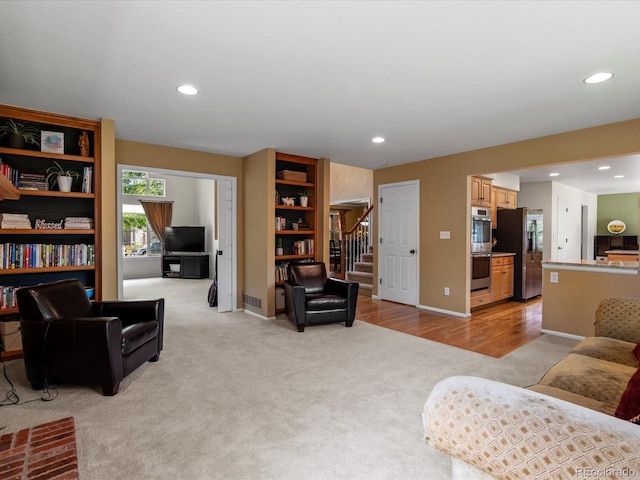 8953 W Brandt Pl, Littleton, CO 80123 - living area featuring light colored carpet, stairs, and recessed lighting