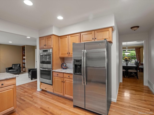 8953 W Brandt Pl, Littleton, CO 80123 - kitchen with stainless steel appliances, light wood-style flooring, light stone countertops, recessed lighting, and light brown cabinets