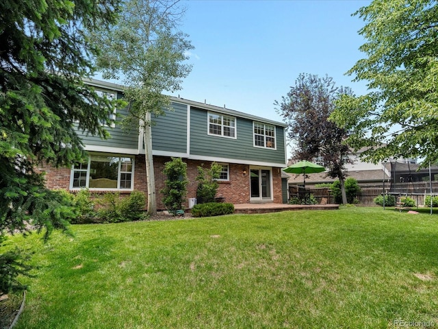 8953 W Brandt Pl, Littleton, CO 80123 - back of property with brick siding, a trampoline, and a patio area