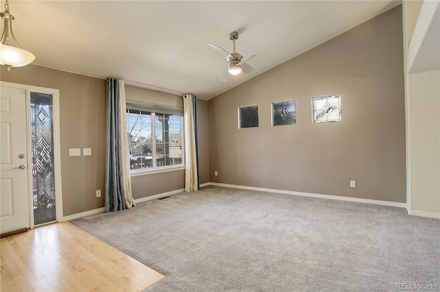 foyer featuring lofted ceiling, light carpet, and ceiling fan