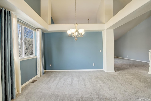 carpeted spare room featuring a high ceiling and an inviting chandelier