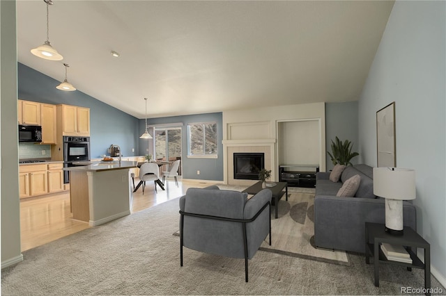 carpeted living room with a fireplace and high vaulted ceiling