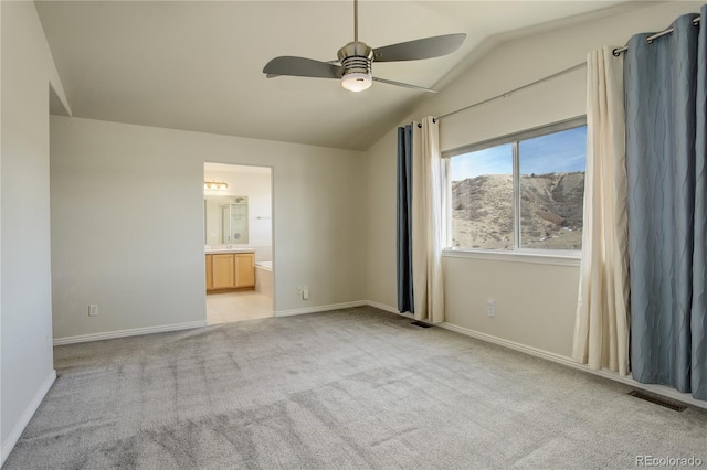 unfurnished bedroom with ceiling fan, lofted ceiling, ensuite bathroom, and light carpet