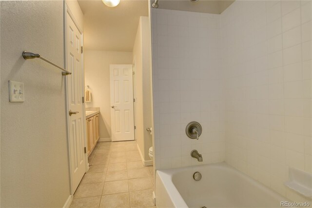 full bathroom featuring tile patterned floors, vanity, toilet, and tiled shower / bath combo