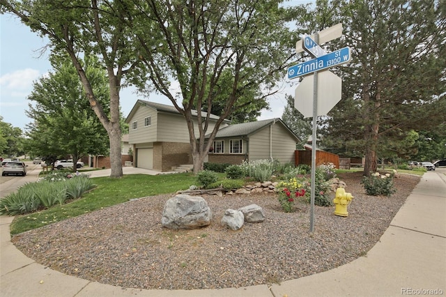 6514 Zinnia St, Arvada, CO 80004 - view of front of house with brick siding, a garage, and driveway