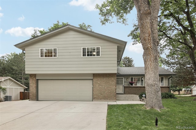 6514 Zinnia St, Arvada, CO 80004 - view of front facade with brick siding, a front yard, a garage, and concrete driveway