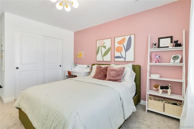 bedroom featuring a closet, an inviting chandelier, and carpet flooring