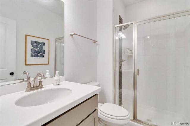 bathroom featuring toilet, vanity, and an enclosed shower