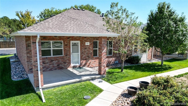 view of front of property featuring a front lawn and a patio