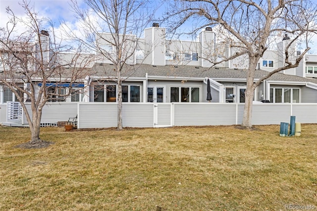 rear view of property with a lawn