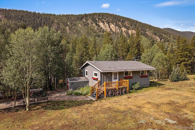 3938 County Road 60, Grant, CO 80448 - rear view of house with a forest view, a lawn, and a deck with mountain view