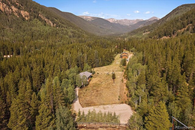 3938 County Road 60, Grant, CO 80448 - aerial view of property and surrounding area with a heavily wooded area and a mountain backdrop