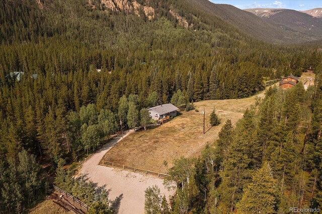 3938 County Road 60, Grant, CO 80448 - view of subject property featuring a heavily wooded area and a mountain backdrop
