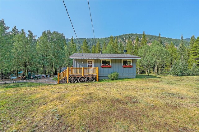 3938 County Road 60, Grant, CO 80448 - rear view of property with a wooded view, a yard, board and batten siding, and a wooden deck
