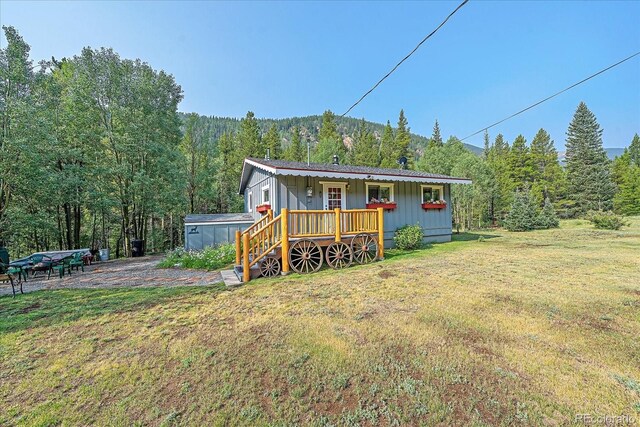 3938 County Road 60, Grant, CO 80448 - back of house featuring a lawn, a wooded view, board and batten siding, and a wooden deck