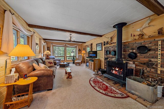 3938 County Road 60, Grant, CO 80448 - carpeted living area with beamed ceiling, a wood stove, a chandelier, and wooden walls