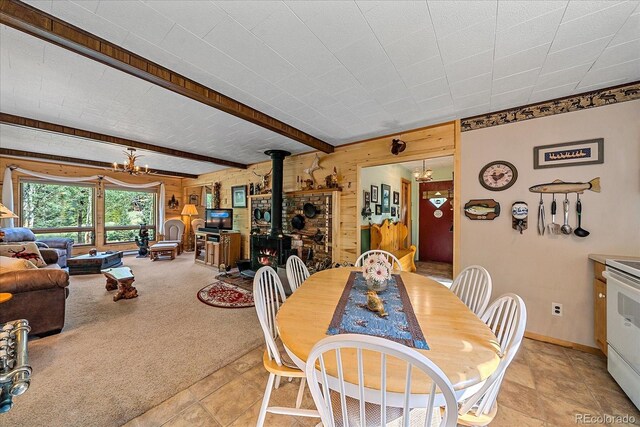 3938 County Road 60, Grant, CO 80448 - dining room with a wood stove, wood walls, a chandelier, light carpet, and baseboards