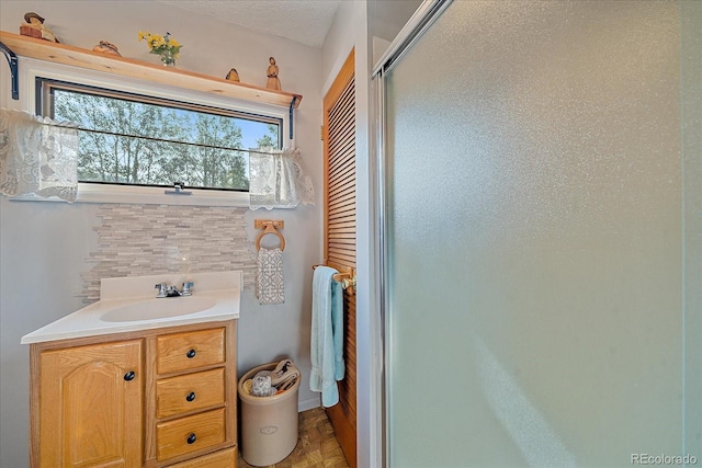 3938 County Road 60, Grant, CO 80448 - bathroom featuring a shower stall, vanity, and tasteful backsplash
