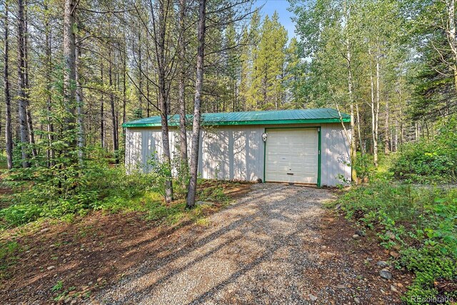 3938 County Road 60, Grant, CO 80448 - garage featuring driveway and a view of trees