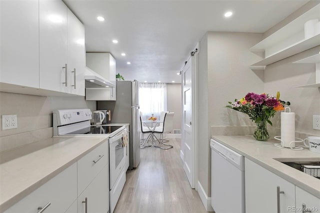 kitchen with white cabinetry, white appliances, wall chimney range hood, and light hardwood / wood-style flooring