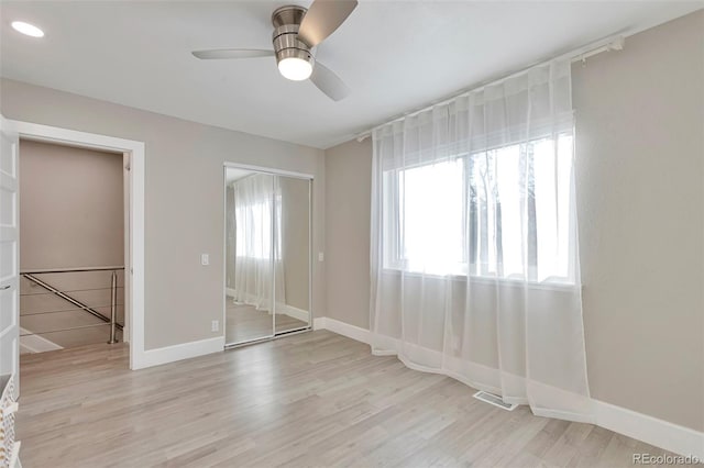 empty room with ceiling fan and light wood-type flooring