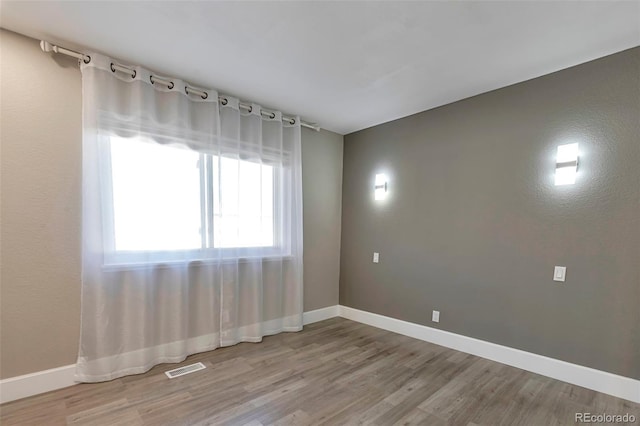 empty room with hardwood / wood-style floors