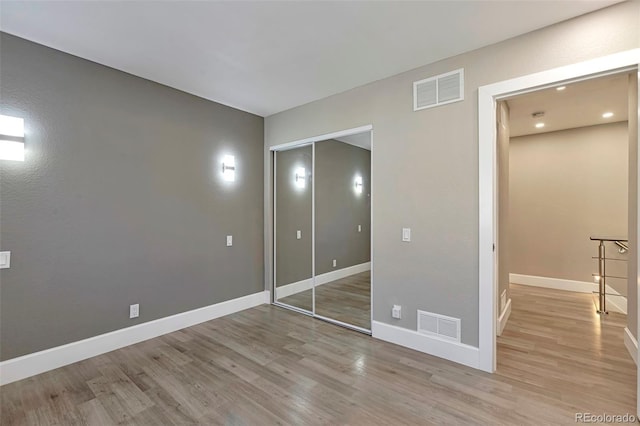 unfurnished bedroom with light hardwood / wood-style floors and a closet