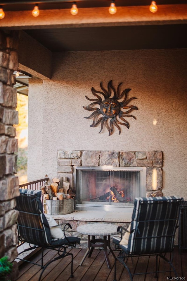 exterior details featuring beamed ceiling and a fireplace