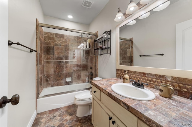 full bathroom with toilet, tasteful backsplash, vanity, and shower / bath combination with glass door