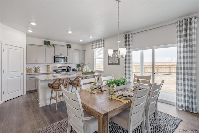 dining area with plenty of natural light, dark wood-type flooring, and a notable chandelier