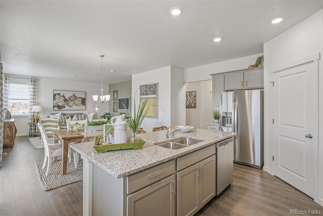 kitchen with appliances with stainless steel finishes, sink, a center island with sink, decorative light fixtures, and gray cabinets