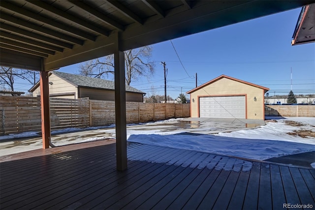 snow covered deck with a garage and an outdoor structure