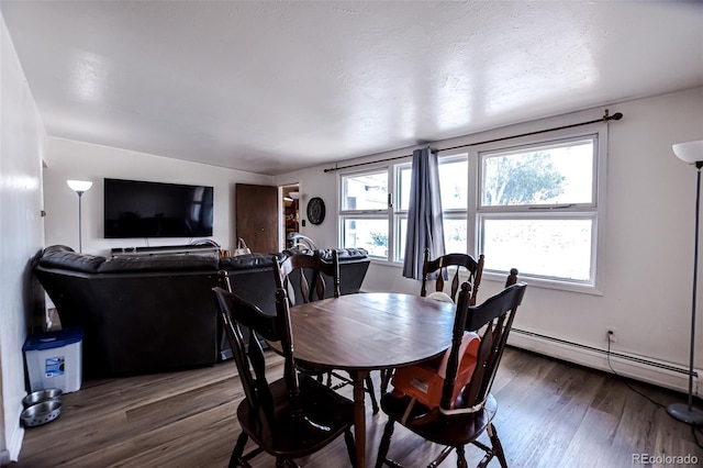 dining area with dark wood-type flooring and a baseboard radiator