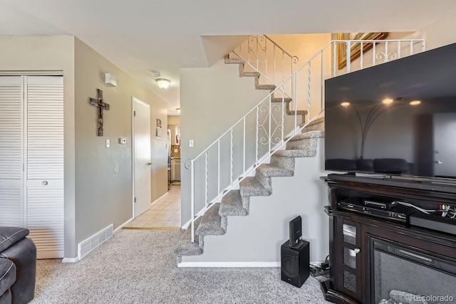 stairway featuring carpet