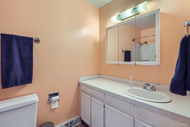 bathroom featuring vanity, a shower, and toilet