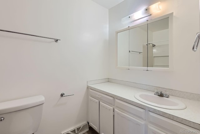 bathroom featuring walk in shower, vanity, and toilet