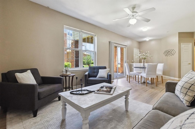 12914 Ironstone Way Unit 102, Parker, CO 80134 - living room featuring light wood-style flooring, a ceiling fan, and baseboards