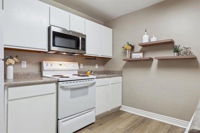 12914 Ironstone Way Unit 102, Parker, CO 80134 - kitchen with stainless steel microwave, white electric stove, open shelves, light wood-style floors, and white cabinetry