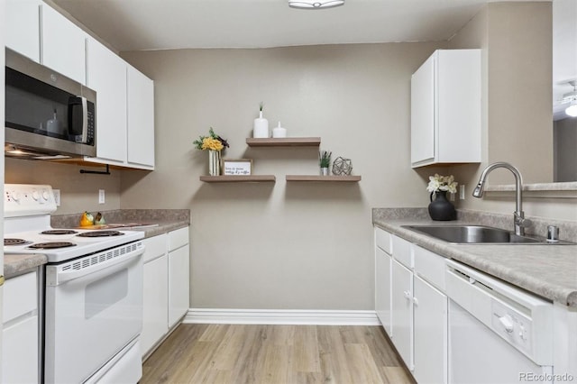 12914 Ironstone Way Unit 102, Parker, CO 80134 - kitchen featuring white appliances, a sink, light wood-type flooring, white cabinetry, and light countertops