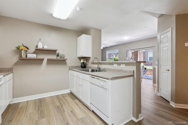 12914 Ironstone Way Unit 102, Parker, CO 80134 - kitchen with a sink, dishwasher, a peninsula, light wood-style flooring, and white cabinets