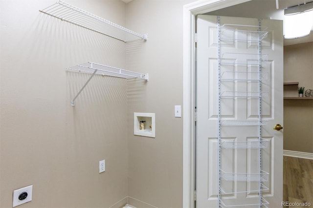 12914 Ironstone Way Unit 102, Parker, CO 80134 - washroom featuring hookup for an electric dryer, hookup for a washing machine, baseboards, and wood finished floors