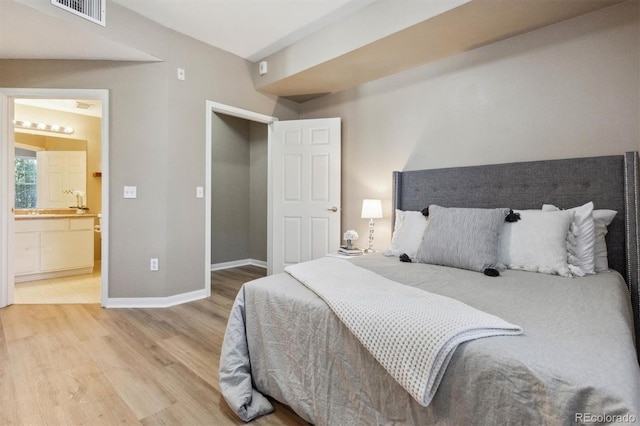 12914 Ironstone Way Unit 102, Parker, CO 80134 - bedroom featuring light wood finished floors, baseboards, and ensuite bath