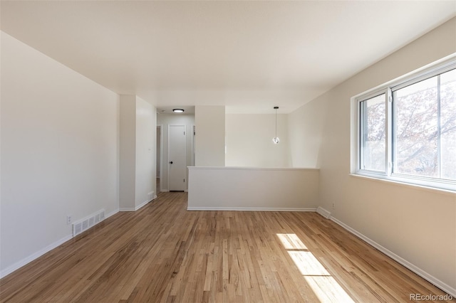 unfurnished room with visible vents, baseboards, and light wood-style floors